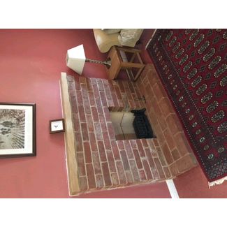 Brick fireplace with a clay fireback for an open fire