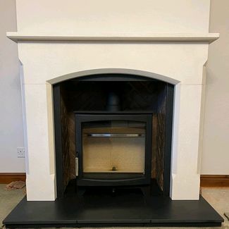 Parkray Aspect 8 woodburner, 54 Capital fireplaces Bellingham mantel in Aegean limestone, Rustic herringbone brick chamber set, Honed granite hearth.